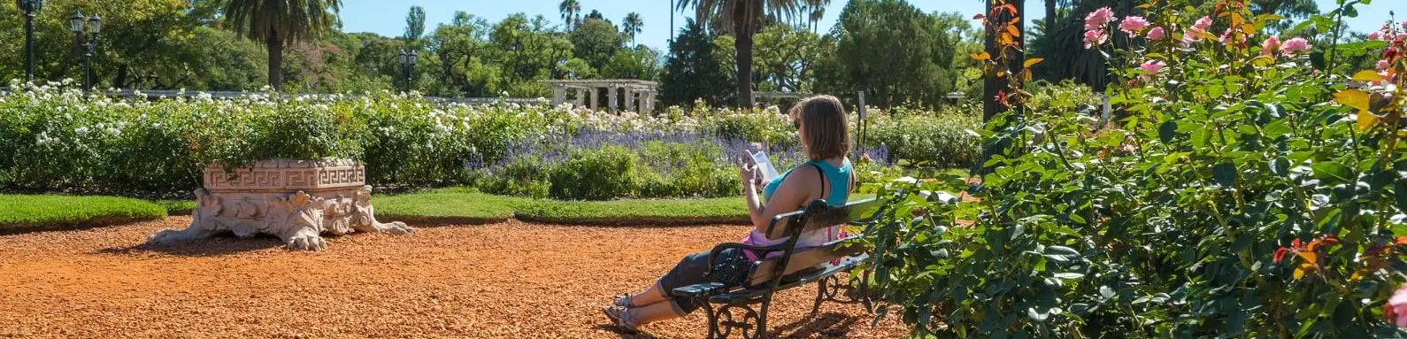 Frau sitzt im Park von Palermo und liest