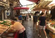 Mann ordnet auf dem Mercato Del Capo an einem Fischstand die Auslage