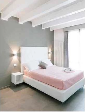 Blick auf ein Bett mit heller Bettwäsche